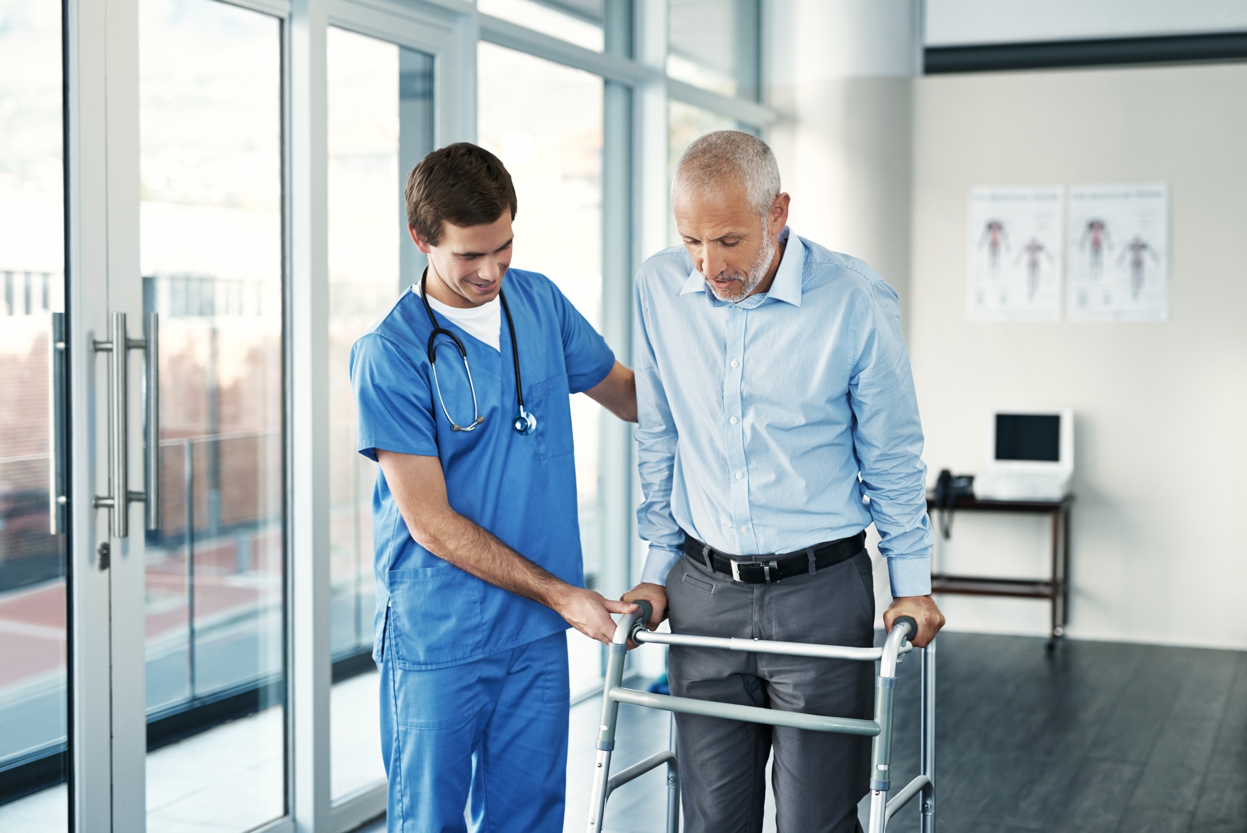 Shot of a male nurse assisting a senior patient with a walker